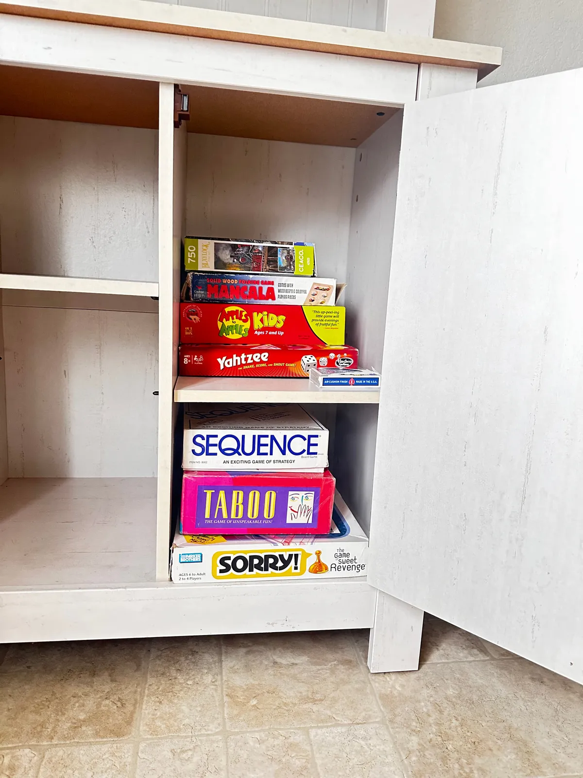 A playful and nostalgic display of various board games neatly arranged in a cabinet, ready for guests to use. The setting suggests memorable game nights and shared laughter after a day spent exploring the outdoors.